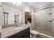 Granite countertop and large tile shower bathroom featuring a rustic wood storage cabinet at 3934 N Quatar Ct, Aurora, CO 80019