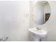 Small bathroom with a pedestal sink and a round mirror at 3934 N Quatar Ct, Aurora, CO 80019