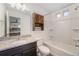 Clean bathroom with granite counters, shower, and wooden storage for functional style at 3934 N Quatar Ct, Aurora, CO 80019