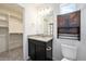 Bathroom featuring granite countertop, modern fixtures, and storage with a walk-in closet access at 3934 N Quatar Ct, Aurora, CO 80019
