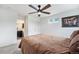 Well-lit bedroom with an attached bathroom, ceiling fan, closet, and soft carpet flooring at 3934 N Quatar Ct, Aurora, CO 80019