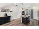 Modern kitchen featuring a kitchen island with granite counters, a stainless dishwasher, and dark wood cabinets at 3934 N Quatar Ct, Aurora, CO 80019