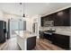 Modern kitchen with a large kitchen island, stainless steel appliances, and dark wood cabinets at 3934 N Quatar Ct, Aurora, CO 80019