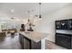Open concept kitchen with kitchen island, dark cabinets, and stainless appliances at 3934 N Quatar Ct, Aurora, CO 80019