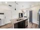 Modern kitchen featuring a kitchen island with granite counters, a stainless dishwasher, and dark wood cabinets at 3934 N Quatar Ct, Aurora, CO 80019