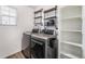 Well-organized laundry room featuring modern washer and dryer, industrial shelving, and bright window at 3934 N Quatar Ct, Aurora, CO 80019