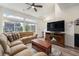 Bright living room features a cozy fireplace, TV, and lots of windows and light at 3934 N Quatar Ct, Aurora, CO 80019