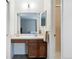 Bathroom vanity with wood cabinets, white counter, large mirror and lighting, plus view to tub/shower at 466 S Kingston Cir, Aurora, CO 80012