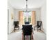 Simple dining area with four chairs, a chandelier, and a window with natural light at 466 S Kingston Cir, Aurora, CO 80012