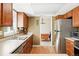 Kitchen with wooden cabinets, white countertops, stainless steel refrigerator, and hardwood floors at 466 S Kingston Cir, Aurora, CO 80012