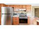 Kitchen with stainless steel refrigerator, oak cabinets, white countertops, and hardwood floors at 466 S Kingston Cir, Aurora, CO 80012