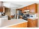 Kitchen with oak cabinets, white countertops, stainless steel refrigerator, and hardwood floors at 466 S Kingston Cir, Aurora, CO 80012