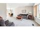 Spacious living room featuring neutral carpet, a large sofa, and ample natural light at 466 S Kingston Cir, Aurora, CO 80012