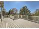 Wide-angle view of an expansive deck with white railings surrounded by mature trees and greenery at 3549 Mallard Dr, Highlands Ranch, CO 80126