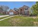 Inviting brick and tan two-story home featuring a well-maintained lawn and attached two car garage at 3549 Mallard Dr, Highlands Ranch, CO 80126