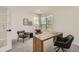 Home office features a unique wood desk, comfortable seating and lots of natural light from corner windows at 3549 Mallard Dr, Highlands Ranch, CO 80126