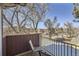 Relaxing balcony with a comfortable chair overlooking the neighborhood and mature trees at 820 Kimbark St # B, Longmont, CO 80501