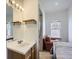 Bathroom vanity featuring a mirror with an adjoining bedroom and seating area at 820 Kimbark St # B, Longmont, CO 80501