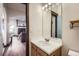 Bathroom vanity featuring a mirror and entryways to other rooms with a view of the fireplace at 820 Kimbark St # B, Longmont, CO 80501
