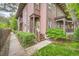 Charming exterior of a multi-story home with a covered porch, lush greenery, and manicured landscaping at 820 Kimbark St # B, Longmont, CO 80501