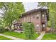 Quaint exterior of a multi-story home with a covered porch, lush trees, and a sidewalk at 820 Kimbark St # B, Longmont, CO 80501