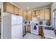 Well-lit kitchen featuring wooden cabinets, white appliances, tile floors, and stainless steel dishwasher at 820 Kimbark St # B, Longmont, CO 80501