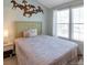 Bedroom featuring a comfortable bed, horse wall art, and a window letting in natural light at 9640 W Chatfield Ave # A, Littleton, CO 80128