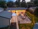 Aerial view of a backyard featuring an outdoor kitchen, patio seating, firepit, and manicured lawn with string lights at 1260 Hoyt St, Lakewood, CO 80215
