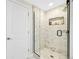 Modern bathroom featuring glass-enclosed shower with niche, and white tiled walls at 1260 Hoyt St, Lakewood, CO 80215