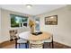 Bright dining room with a round table, stylish chairs, hardwood floors, and a view of the backyard at 1260 Hoyt St, Lakewood, CO 80215