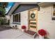 Cozy front porch decorated with flower pots, lanterns, and a welcoming door mat by a modern front door at 1260 Hoyt St, Lakewood, CO 80215