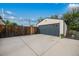Detached garage featuring a large driveway, modern doors, and landscaping for added curb appeal at 1260 Hoyt St, Lakewood, CO 80215