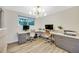 Spacious home office with dual desks, a large window, modern lighting, and grey storage cabinets at 1260 Hoyt St, Lakewood, CO 80215