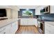 Bright kitchen featuring white cabinetry, stainless steel appliances, blue backsplash, and quartz countertops at 1260 Hoyt St, Lakewood, CO 80215