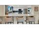 Modern kitchen featuring white cabinetry, a stainless steel microwave and refrigerator, and stylish bar seating at 1260 Hoyt St, Lakewood, CO 80215