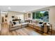 Bright and spacious living room featuring hardwood flooring, a comfortable sectional sofa, and modern decor at 1260 Hoyt St, Lakewood, CO 80215