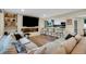 Modern living room featuring an electric fireplace, large TV, hardwood flooring, and an opening to the kitchen at 1260 Hoyt St, Lakewood, CO 80215