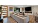 Bright living room featuring hardwood floors, a stylish sectional sofa, large windows, and an electric fireplace at 1260 Hoyt St, Lakewood, CO 80215