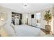Bright main bedroom with an organized walk-in closet, modern light fixture, and a view of the bath at 1260 Hoyt St, Lakewood, CO 80215
