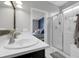 Elegant bathroom featuring double sinks, marble counters, a walk-in shower, and a bedroom view at 19210 E Pacific Pl, Aurora, CO 80013