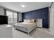 This bedroom boasts a decorative blue accent wall, a large window, and a queen bed at 19210 E Pacific Pl, Aurora, CO 80013
