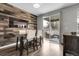 Stylish dining area with a wood accent wall, modern lighting, and access to outdoor seating at 19210 E Pacific Pl, Aurora, CO 80013