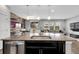 Granite island with stainless steel dishwasher, seating and modern lighting at 19210 E Pacific Pl, Aurora, CO 80013