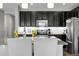 Modern kitchen featuring stainless steel appliances, dark cabinets, and a granite countertop island at 19210 E Pacific Pl, Aurora, CO 80013