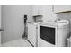 Well-equipped laundry room featuring a washer, dryer, and convenient storage cabinets at 19210 E Pacific Pl, Aurora, CO 80013