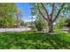 Expansive backyard with well-maintained lawn and mature trees provides ample space for recreation at 2816 S Wolff St, Denver, CO 80236