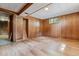 Basement rec room with wood paneled walls, closet, new flooring and window at 2816 S Wolff St, Denver, CO 80236