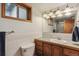 Bathroom with vanity, sink, toilet, tiled walls and a mirror with decorative lighting at 2816 S Wolff St, Denver, CO 80236