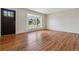 Bright living room featuring gleaming hardwood floors, a large bay window, and neutral walls at 2816 S Wolff St, Denver, CO 80236
