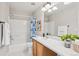 Bright bathroom with a tub-shower combo, wooden vanity, and classic finishes at 2362 Xanthia Way, Denver, CO 80238